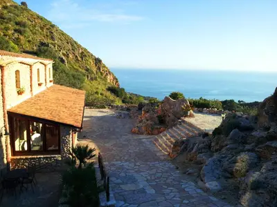 a building on the side of a mountain at Casale Corcella in Scopello