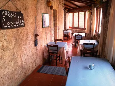 a restaurant with tables and chairs and a sign on the wall at Casale Corcella in Scopello