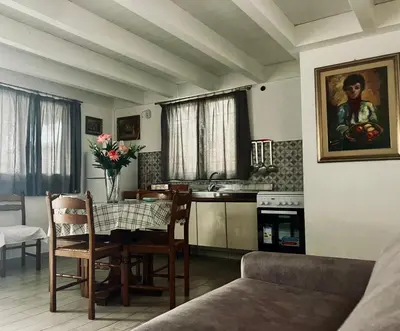 a living room with a table and a kitchen at Itaca in Palermo