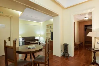 a living room with a table and a couch at Eurostars Centrale Palace Hotel in Palermo