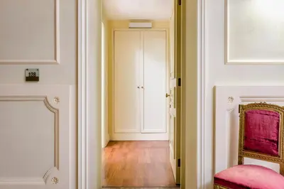 a hallway with a pink chair and a door at Eurostars Centrale Palace Hotel in Palermo