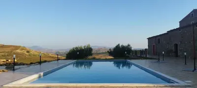 a large swimming pool in front of a building at Masseria Baglio Perciata in Camporeale