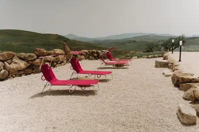 a row of chairs sitting on a beach at Masseria Baglio Perciata in Camporeale