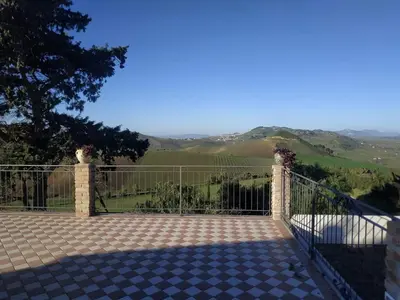 a gate with a view of the hills at Masseria Baglio Perciata in Camporeale