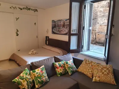 a living room with a couch and a bed at Aspettando Vossia in Palermo