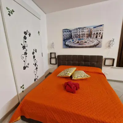 a bedroom with an orange bed with two pillows at Aspettando Vossia in Palermo