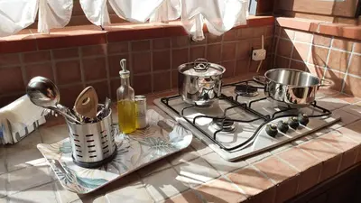a kitchen counter with two pots and pans on a stove at Casetta delle Mimose in Isola delle Femmine
