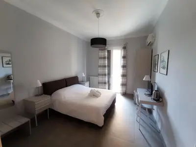 a bedroom with a bed and a desk and a computer at Donna Franca Rooms and Suite in Palermo