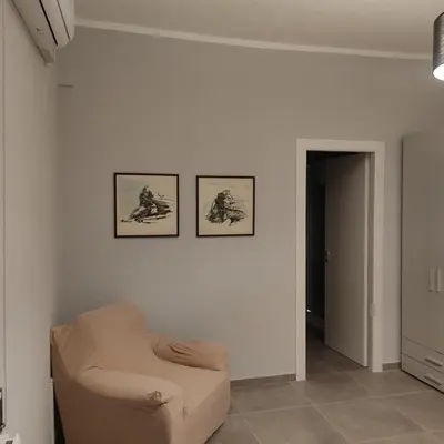 a living room with a chair and two pictures on the wall at Donna Franca Rooms and Suite in Palermo