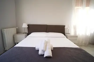 a bedroom with a white bed with towels on it at Donna Franca Rooms and Suite in Palermo