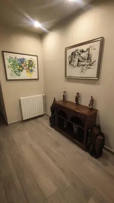 a living room with a fireplace and two pictures on the wall at Donna Franca Rooms and Suite in Palermo
