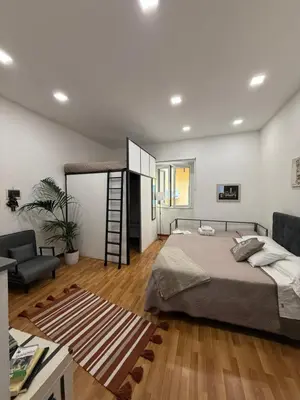 a bedroom with a bed and a living room at Casetta Mape in Palermo