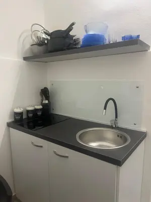 a kitchen counter with a sink and a shelf at Casetta Mape in Palermo