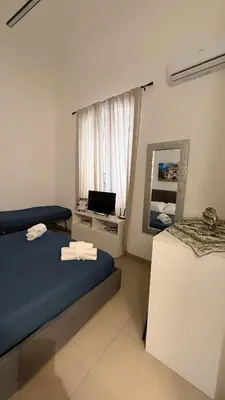 a bedroom with a bed and a mirror and a television at Casetta Mape in Palermo