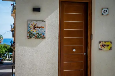 a door to a house with a picture on the wall at Kalifè Vacanze in Castellammare del Golfo