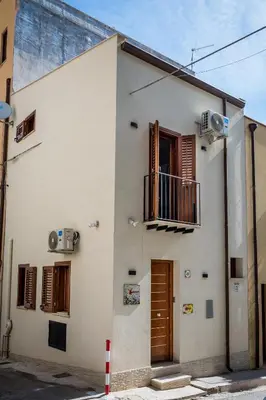 a white building with a balcony and a window at Kalifè Vacanze in Castellammare del Golfo