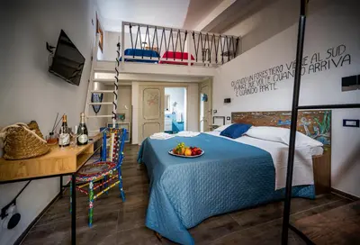 a bedroom with a bed with a bowl of fruit on it at Kalifè Vacanze in Castellammare del Golfo