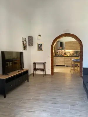 a living room with a couch and a tv and a table at Casa in piazzetta in Balestrate