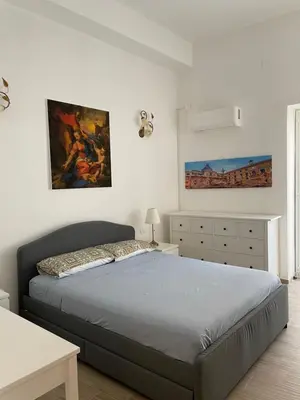 a bedroom with a bed and a painting on the wall at Casa in piazzetta in Balestrate