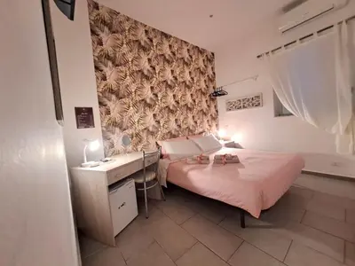 a bedroom with a bed and a desk and a wall at Affittacamere Ammirata in Palermo
