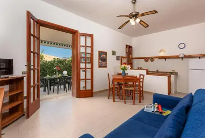 a living room with a blue couch and a table at Casa Vacanza Azzurra 2 in San Vito lo Capo