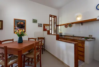 a kitchen and dining room with a table and a sink at Casa Vacanza Azzurra 2 in San Vito lo Capo