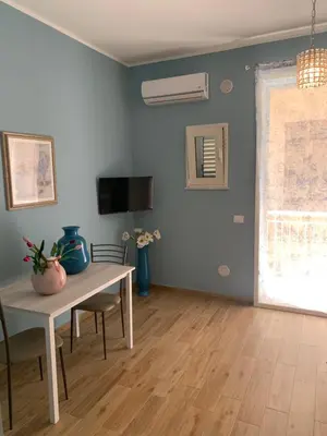 a living room with a table and a window at Denise Vacanze - Monolocali arredati in Bagheria