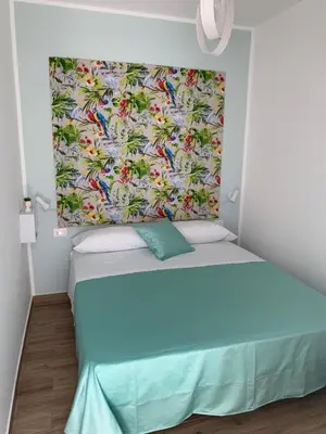 a bed in a room with a colorful blanket at Denise Vacanze - Monolocali arredati in Bagheria