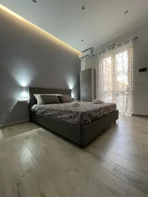 a bedroom with a bed and a large window at Goccia del mare in Isola delle Femmine