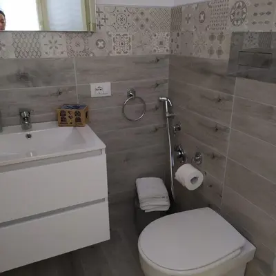a bathroom with a white toilet and a sink at Goccia del mare in Isola delle Femmine