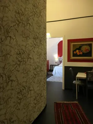a bedroom with a bed and a mirror and a table at BeeClaire Guest House in Palermo