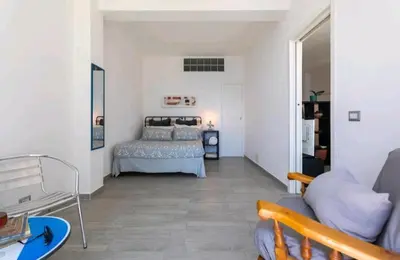 a living room with a bed and a couch at Villa's apartment on the beach, swimming pool A/C in Palermo