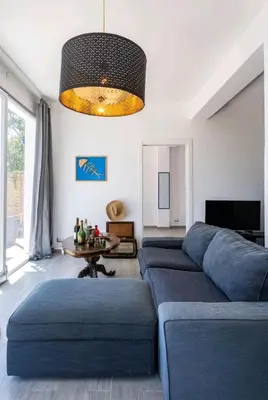 a living room with a blue couch and a table at Villa's apartment on the beach, swimming pool A/C in Palermo