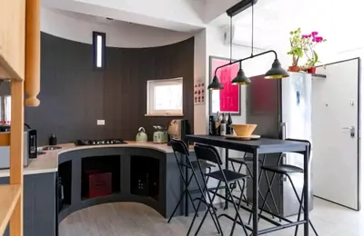 a kitchen with a black island with a table and chairs at Villa's apartment on the beach, swimming pool A/C in Palermo