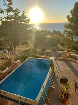a swimming pool with a view of the ocean at Villa's apartment on the beach, swimming pool A/C in Palermo