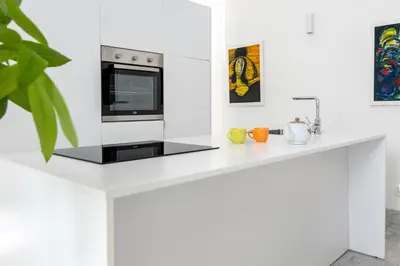 a white kitchen with a counter with a microwave at Suite Bellini 5 Apartment in Palermo