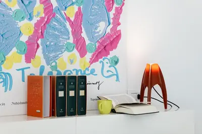 a shelf with books and a chair next to a wall at Suite Bellini 5 Apartment in Palermo
