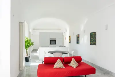 a living room with a red couch and a table at Suite Bellini 5 Apartment in Palermo