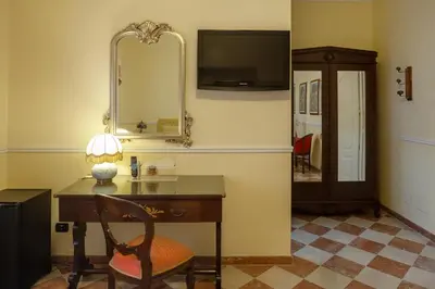 a room with a desk with a chair and a mirror at Hotel Trinacria in Palermo