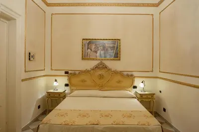 a bedroom with a bed and two nightstanduments at Hotel Trinacria in Palermo
