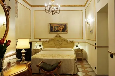 a bedroom with a bed and a table and a chair at Hotel Trinacria in Palermo