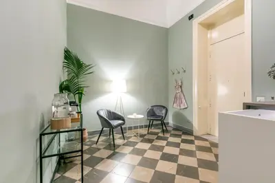 a living room with two chairs and a table at GuestHost - Teatro Massimo Bright and Cozy Apartment in Palermo