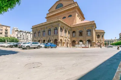a large building with cars parked in front of it at GuestHost - Teatro Massimo Bright and Cozy Apartment in Palermo