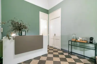 a hallway with green walls and a checkered floor at GuestHost - Teatro Massimo Bright and Cozy Apartment in Palermo