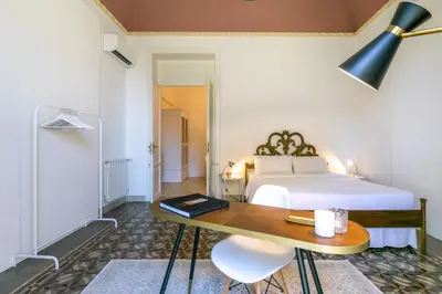 a bedroom with a bed and a table and a desk at GuestHost - Teatro Massimo Bright and Cozy Apartment in Palermo