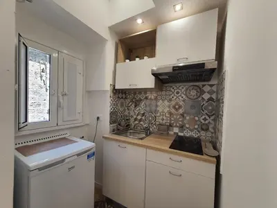 a small kitchen with white cabinets and a sink at A casa di Claudia in Palermo