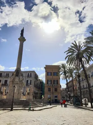 a statue in the middle of a city with buildings at A casa di Claudia in Palermo