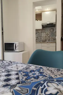 a room with a bed and a kitchen with a microwave at A casa di Claudia in Palermo