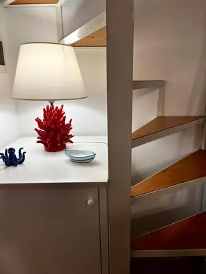a table with a lamp and a bowl on it at Casa Levante in Isola delle Femmine