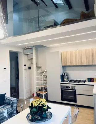 a kitchen and a living room with a loft at Casa Levante in Isola delle Femmine